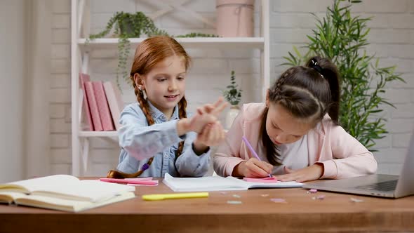 Two Little Children Girl Have Video Call with Teacher Using Laptop for Studying Online.