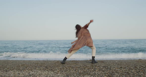 Young girl with black boots has fun on the beach near the sea in Italy