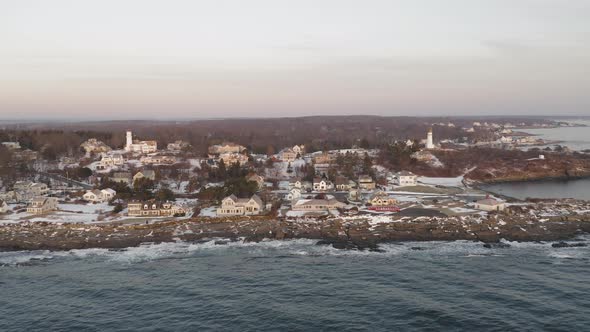 Two Lighthouse in a coastal neighborhood during pink winter sunrise AERIAL SLIDE