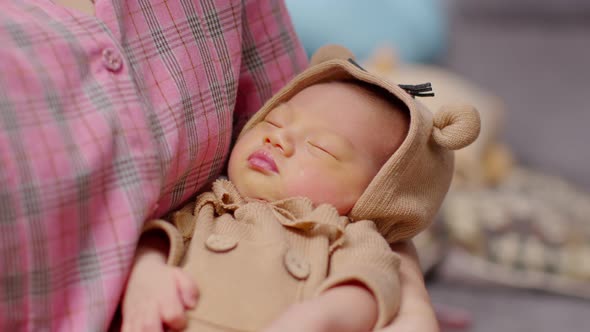 Adorable sleeping newborn baby relax in mother arm safety and comfortable