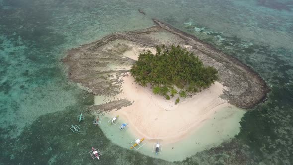 Aerial pedestal down tilting up shot of sandy Guyam Island, Siargao, the Philippines