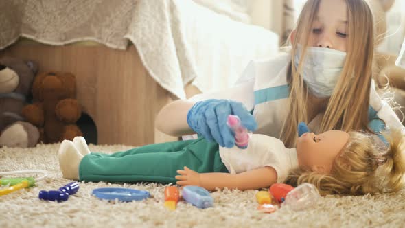 Beautiful Little Girl Playing Doctors with Doll at Home