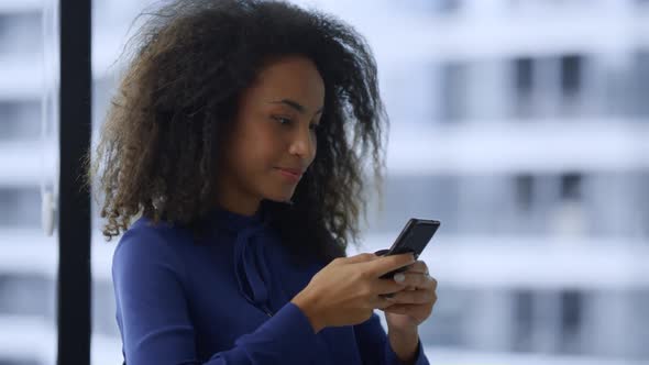 Smiling African American Businesswoman Texting Mobile Phone Internet in Office