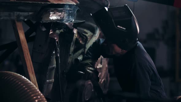 Male Worker Examines Metal Construction to Adjust Some Piece of Metal Detail to It