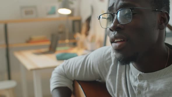 Afro Man Playing Guitar and Singing at Home