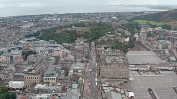 Dolly forward drone shot over Princes street towards Calton hill late evening