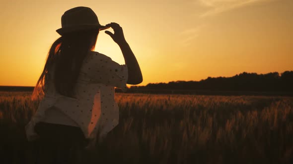 Pretty Child in the Hat Is Running Across the Wheat Field. Happy Young Girl Running in the Field at