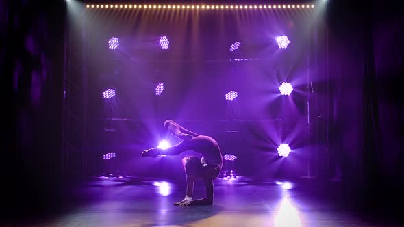 A Girl Artistic Gymnast Performs a Handstand and Balances. Female Athlete Training in a Closed