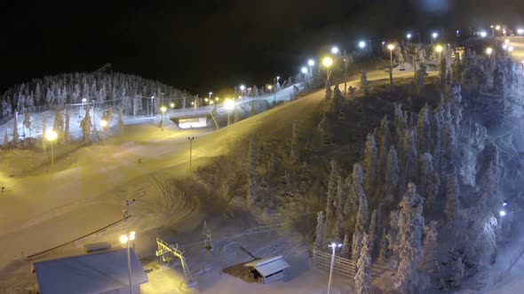 Flying over ski slopes and working lift at night