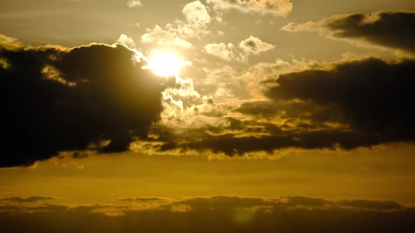 Dramatic Sunset with Sun Rays in Sky Through Orange Layered Clouds Timelapse