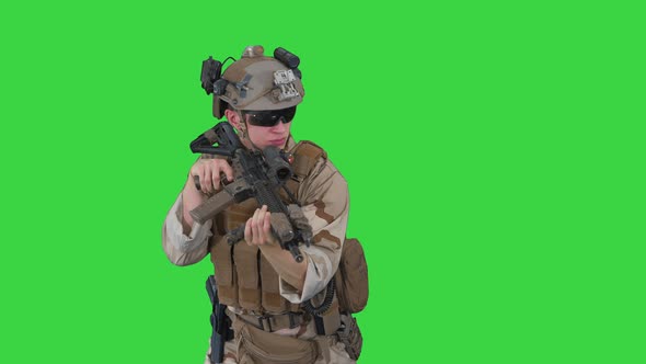 Soldier Looking for Enemy and Aming with Rifle on a Green Screen, Chroma Key.