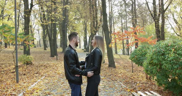 Lovely Couple Rejoices While Stands in Embraces and Caresses in Autumn Park