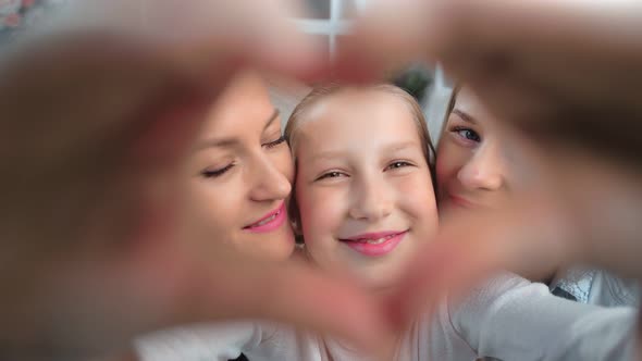 Closeup Face Happy Child Girl Showing Heart Gesture By Hand Posing Two Lesbian Kissing Mother