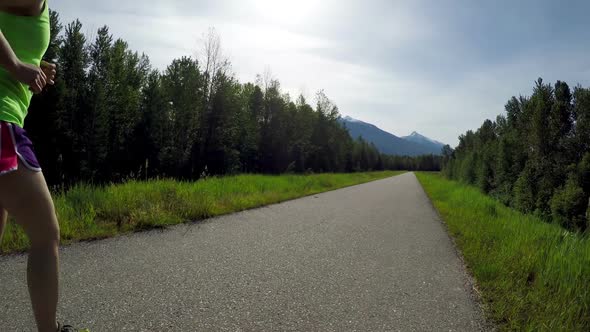 Woman jogging on a country road 4k