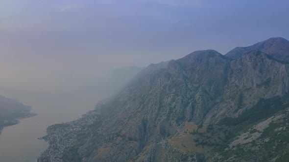 Fog and smoke on the Mountains of Kotor bay in Montenegro. Aerial drone view 4K