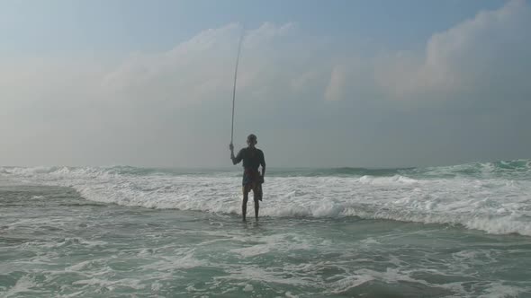 Aged Sinhalese Man with Wooden Fishing Pole at Ocean Slow