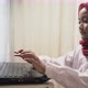 a little girl wearing hijab typing on laptop with headphone - VideoHive Item for Sale