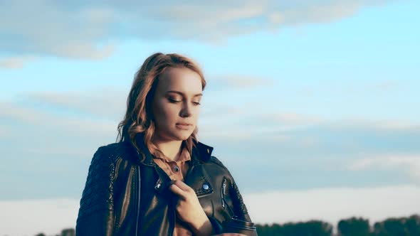 Pretty Girl in a Black Jacket Standing Near the River