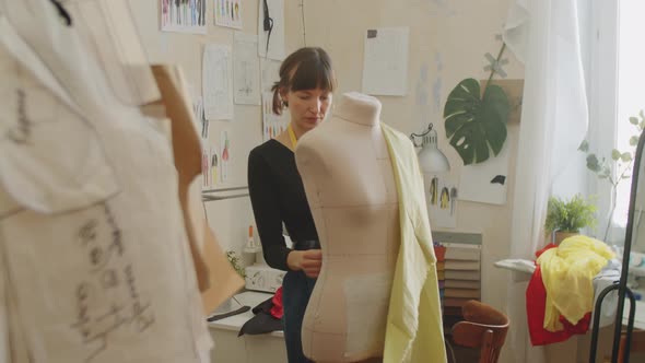 Female Dressmaker Attaching Fabric to Dress Form