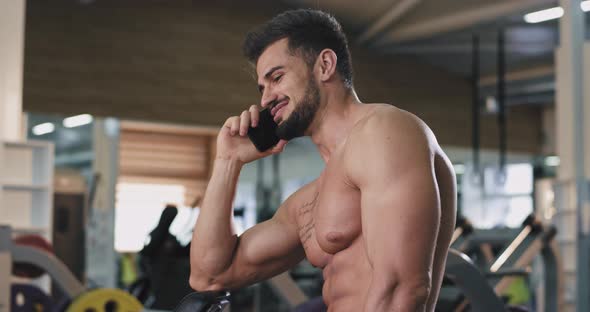 Young Guy with a Fit Body Speaking on Phone in a