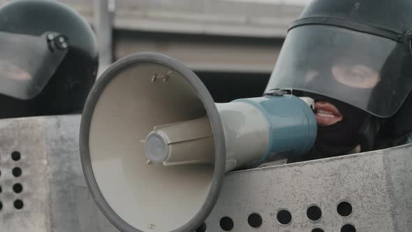 Riot Policeman Talking into Megaphone at Protest