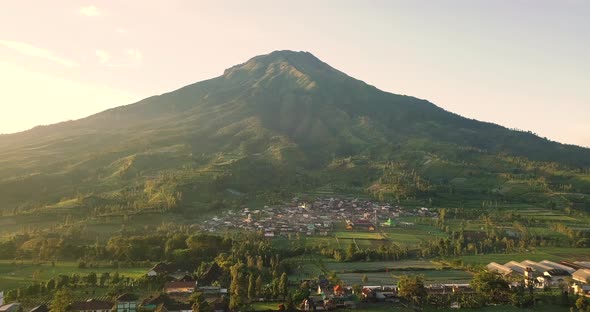 Mount sumbing with rural view and lush trees in tobacco plantations with blue sky on the background