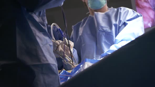 Surgeons working during surgery, close up on hands and instruments.