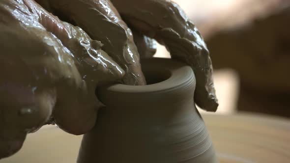 Dirty Hands of Potter Making Pot Close Up