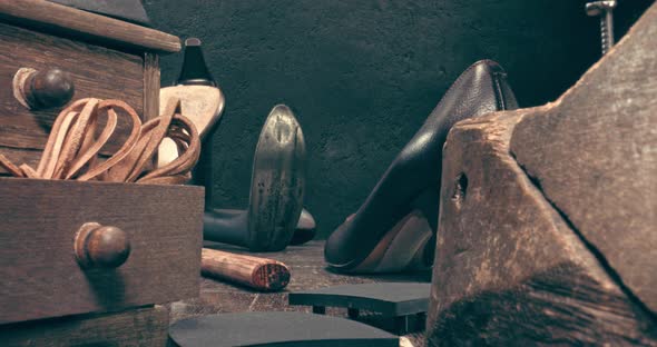 Shoemaker workshop with tools, anvil, shoes and rule.