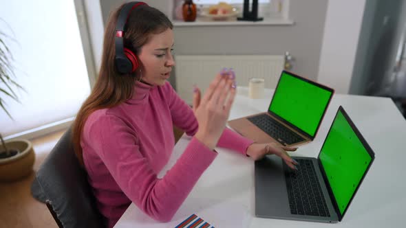 Positive Confident Young Woman in Headphones Listening to Music Messaging on Two Green Screen