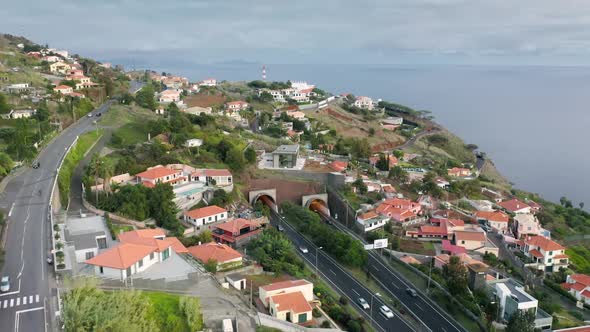 Aerial View of Tunnels and Winding Roads with a Seascape in the Background