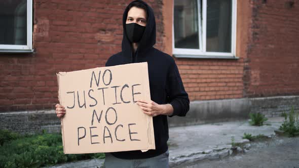 Man in Mask Stands with Cardboard Poster in Hands  BLACK LIVES MATTER