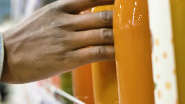 Black Man in Blue Denim Jacket Hand Takes Orange Juice