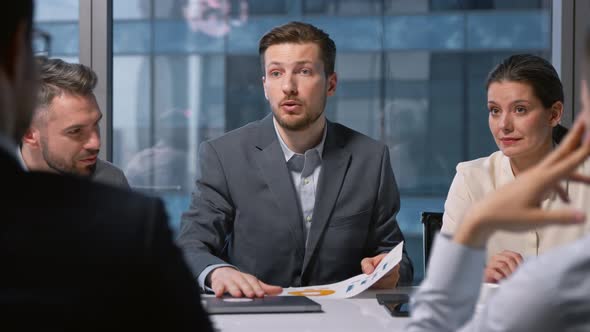 Portrait of a young manager with a strategy in a diagram proposes new ideas to colleagues