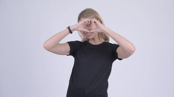 Young Happy Blonde Woman with Hand Heart Gesture