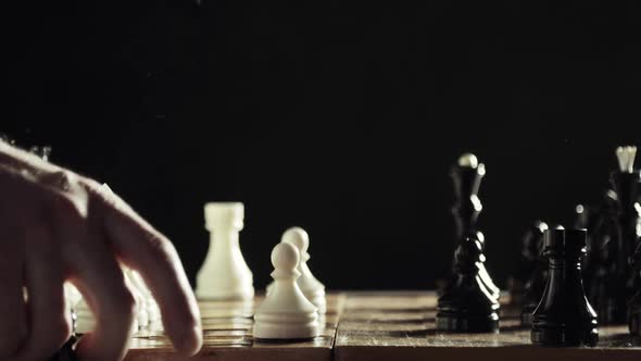 Robotic Hand Prosthesis Is Playing Chess with Human Hand on Black Background