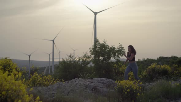 Slow Motion Video of a Girl Jogging Near Windmills