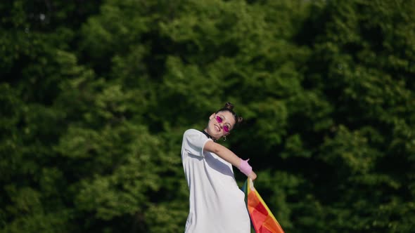 Young Woman Waving LGBT Pride Flag in the Park