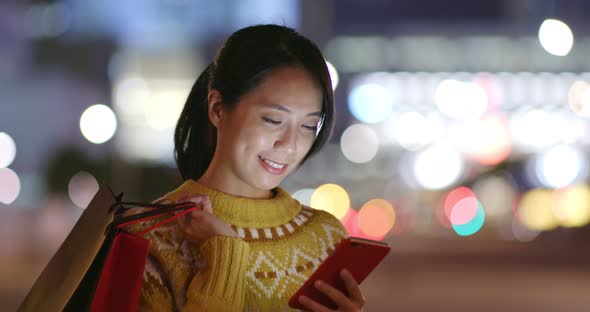 Woman Hold with Shopping Bag and Use of Mobile Phone in City 