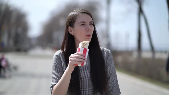 Woman with Long Hair Eating Doner or Shawarma at Spring