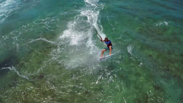 Aerial view of a man kitesurfing in Hawaii.