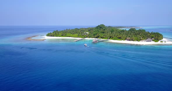 Daytime birds eye island view of a white paradise beach and aqua blue water background in hi res 4K