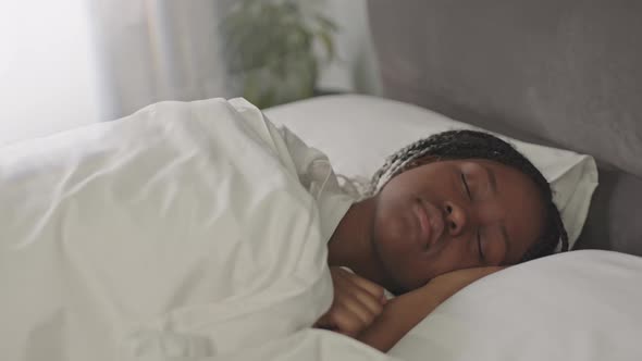 Young Black Woman Sleeping in White Bed