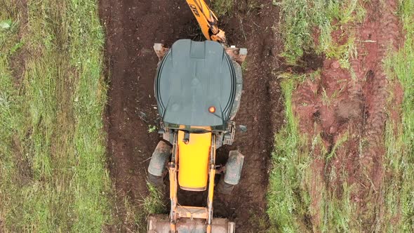 Top view of excavator working in field