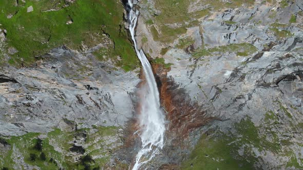 Aerial: drone flying over scenic waterfall and mountain stream on the italian Alps