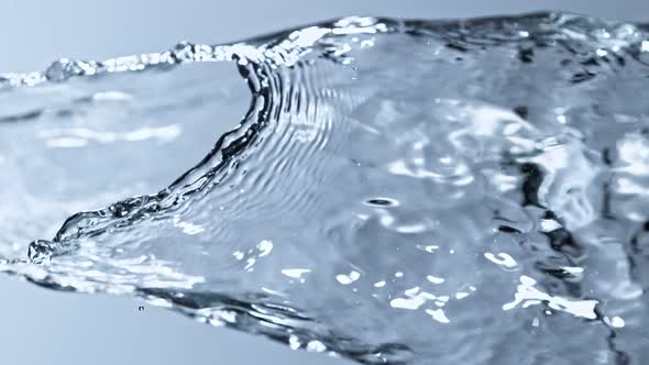 Super Slow Motion Detail Shot of Water Stream on Light Blue Background at 1000Fps