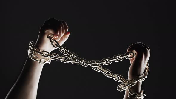 Hands breaking chains. Metal or steel chain is blown to pieces. Break free.