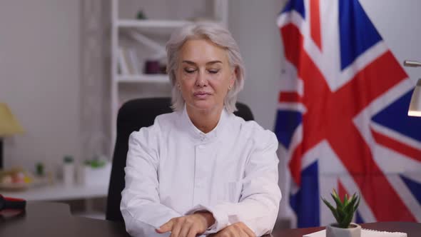 Portrait of Serious Professional Mature Businesswoman Listening Carefully Sitting Indoors in Office