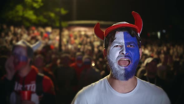 Man with the Paint on His Face Jumps in Delight From the Victory of Soccer.