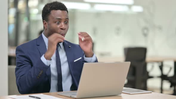 Successful African Businessman Celebrating on Laptop